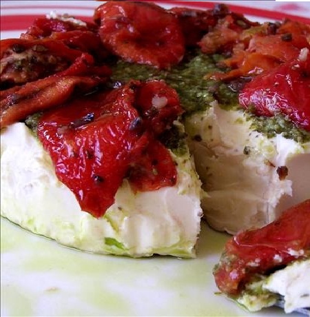 Brie topped with pesto and sun-dried tomatoes