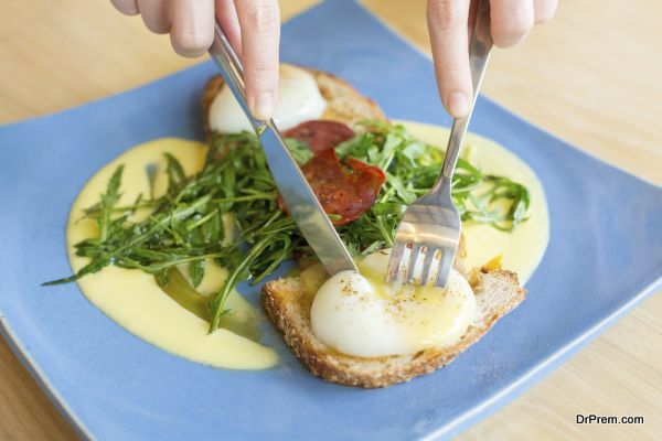 Lady cutting Egg benedict