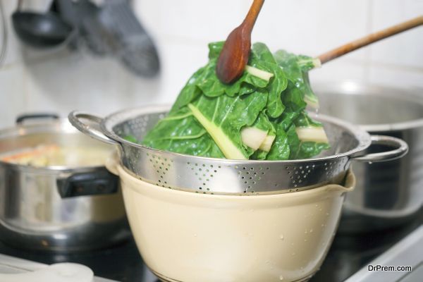 Preparing healthy lunch in the kitchen, blanching chard using kitchen utensils