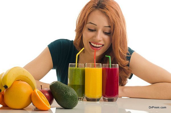 Happy woman holding in front of her three different smoothie