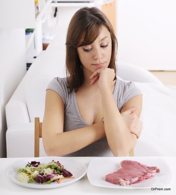 young woman eating salad and meat