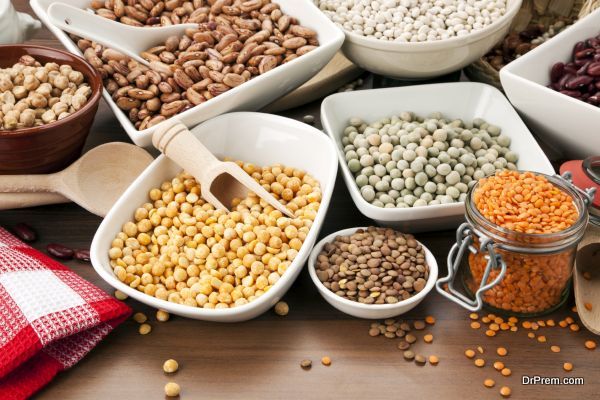 variety of legumes in bowls and glasses, arranged on kitchen table