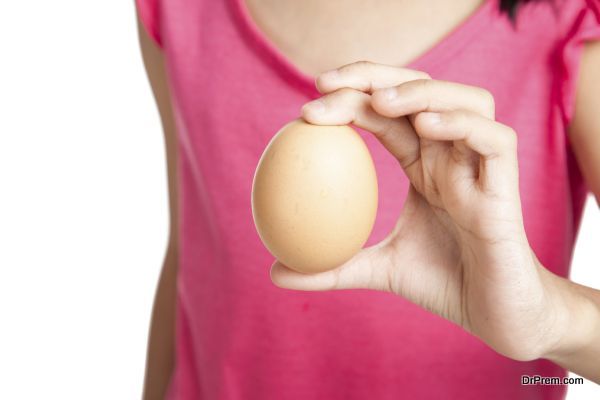 Close up of egg in hand of asian little girl on white background