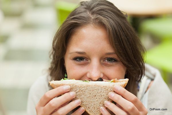 Female student with sandwich in the cafeteria