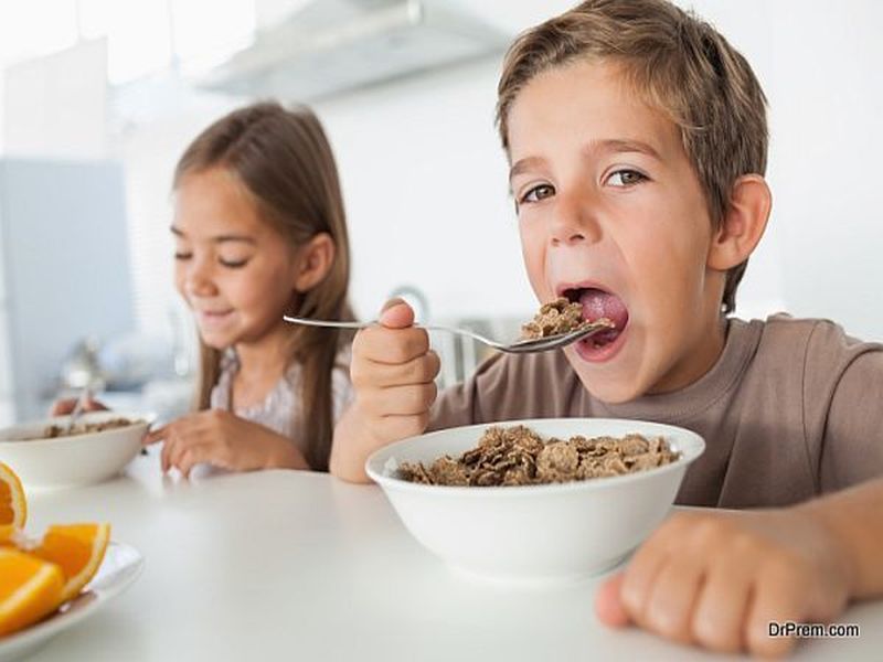 Boy eating cereal while having breakfast